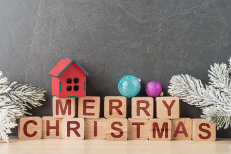 Wooden cubes with caption Merry Christmas and Xmas decoration over grey background with copy spaceの写真素材