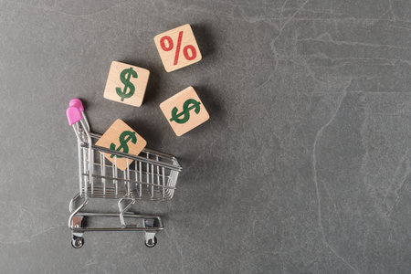 Shopping cart with USD and percentage icons on wooden cubes. Consumer credit conceptの写真素材