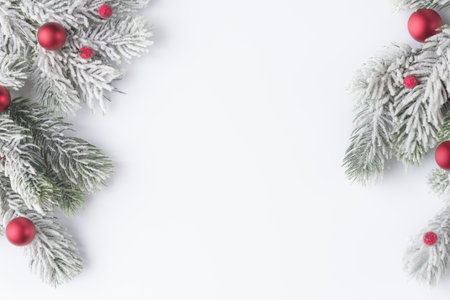 Christmas tree frosty branches with red balls on white background with copy spaceの写真素材