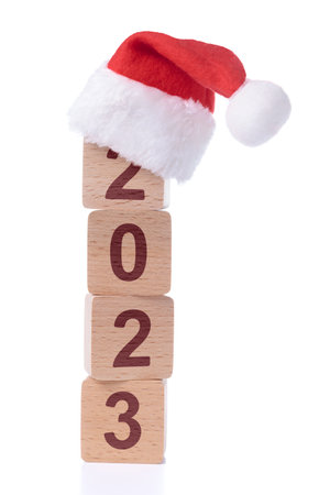 Wooden blocks with number 2023 and Santa hat isolated on white background. Christmas and New Year greeting conceptの写真素材