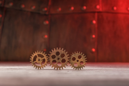 Three gears against metal plates with rivets. Steampunk style conceptの写真素材