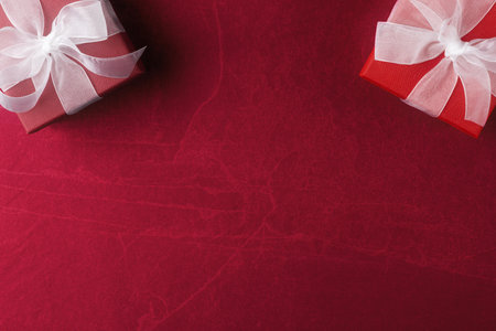 Red gift boxes on dark-red stone background with copy spaceの写真素材