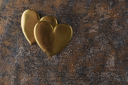 Two golden hearts on grunge metal background with copy space. Valentines day greeting conceptの写真素材