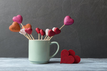 Decorative hearts in cup over stone background with copy space. Valentines day greeting conceptの写真素材