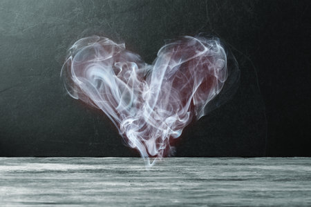 Smoke in a shape of Valentine heart over dark stone background. Valentineâs day conceptual greetingの写真素材