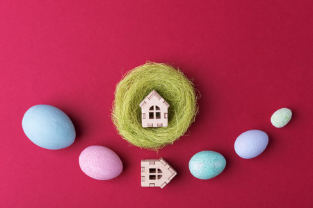 Decorative Easter eggs and house in nest on viva magenta background with copy space. Easter holiday greetingの写真素材