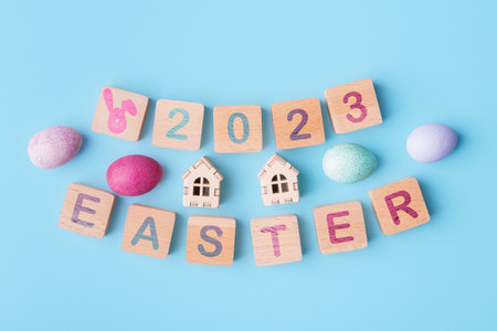 Wooden blocks with lettering 2023 Easter and decorative eggs on blue background. Easter holiday celebration conceptの写真素材