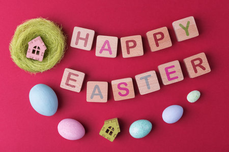 Decorative Easter eggs and wooden blocks with lettering Happy Easter on viva magenta background. Easter holiday conceptの写真素材