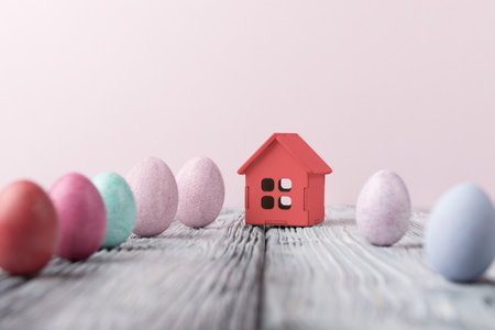 Decorative house and Easter eggs over pinkt background with copy space. Easter holiday greeting conceptの写真素材