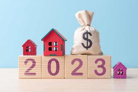 House models, money bag with dollar sign on wooden cubes with number 2023. Concept of mortgage and real estate buying in 2023の写真素材