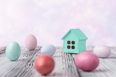 Decorative house and Easter eggs over holiday abstract background with copy space. Easter holiday greeting conceptの写真素材
