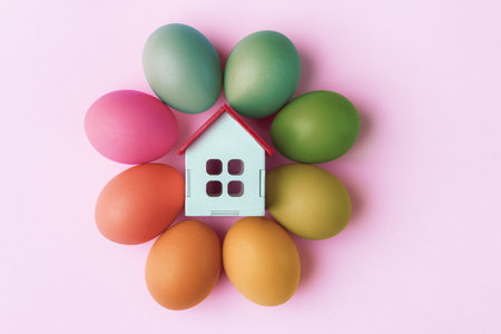 Decorative house and Easter eggs on pink background. Easter holiday greeting conceptの写真素材