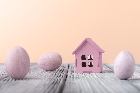 Decorative Easter eggs and house model on pastel background with copy space. Easter holiday conceptの写真素材