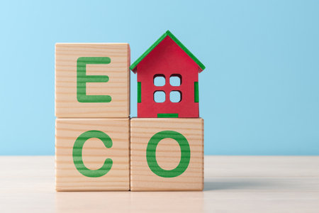 Wooden house model on blocks with letters ECO. Concept of eco-friendly houseの写真素材