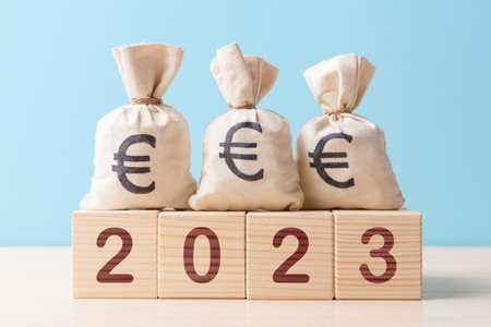 Moneybags with Euro symbol on wooden blocks with digits 2023の写真素材