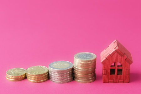 Houses model and Euro coins on pink background. Real estate sectorâs upward trendの写真素材