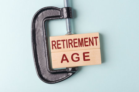 C-clamp  holds wooden blocks with words Retirement age. Concept of cancellation of retirement age increaseの写真素材