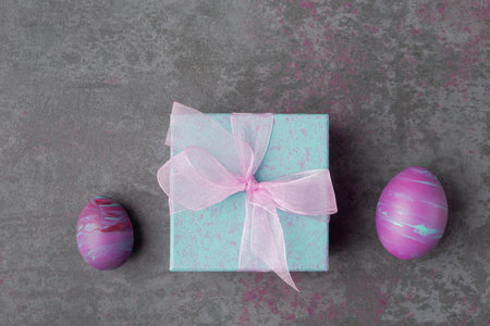 Gift boxes and painted Easter eggs on stone background. Easter gift conceptの写真素材