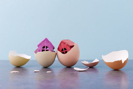 Tiny houses in eggs shell over blue background with copy space. Conceptual Easter greeting cardの写真素材