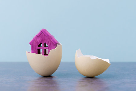 Pink House in egg shell over light blue background with copy space. Conceptual Easter greeting cardの写真素材