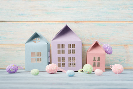 Decorative houses and Easter eggs over wooden background. Easter holiday greeting conceptの写真素材