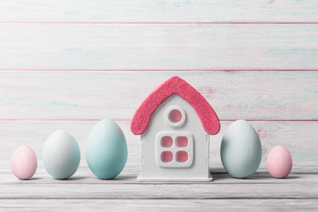 Easter background with decorative house and painted eggs over widen background. Easter greeting conceptの写真素材