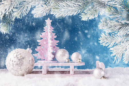 Decorated Christmas tree on Santaâs sleigh over blue background and  frosty Christmas tree branchesの写真素材