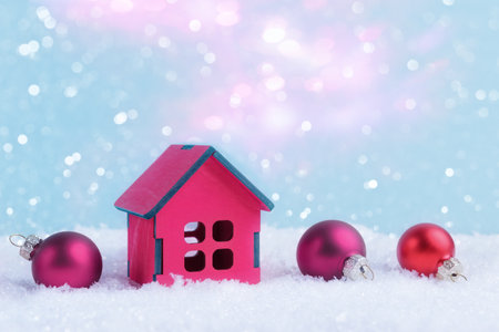 Decorative house and Christmas balls in snow over abstract background with copy space. Xmas and New Year greeting card designの写真素材