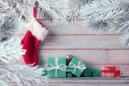 Gift boxes and Santaâs stocking hanging on wooden background. Christmas background with copy space. Conceptual Xmas and New Year greetingの写真素材