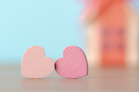 Two decorative hearts over defocused background with house model in red bow. Valentineâs day greeting cardの写真素材