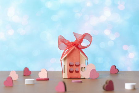 House model with red bow and decorative valentines hearts over holiday defocused lights. Valentineâs day conceptの写真素材