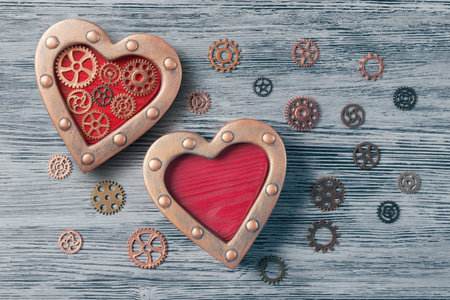 Two steampunk decorated hearts on wooden  background with cogwheels. Valentine's Day concept in steampunk styleの写真素材