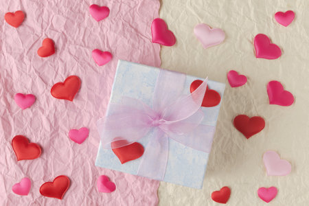 Gift box and fabric decorative hearts on crumpled paper background. Valentineâs day greeting conceptの写真素材