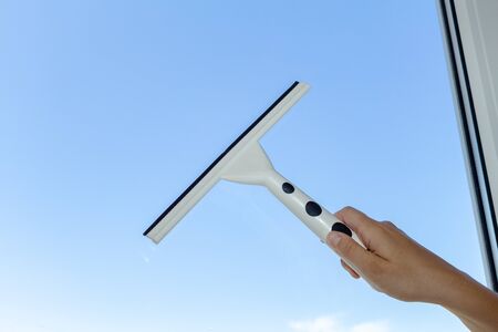 cleaning window with special brush on the the blue sky backgroundの写真素材