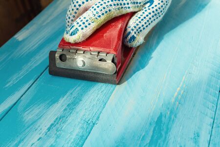 Sanding with Abrasives in a hand sanding paper sponges wooden painted blue wooden table background close upの写真素材