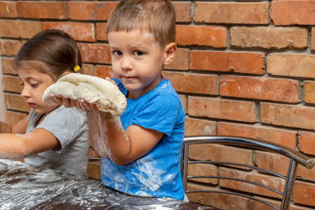Little kids girl and boy dough, preparing dough for baking