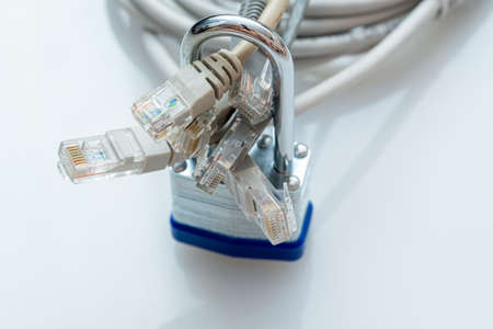 bundle of network wires blocked with metal padlock on white backgroundの写真素材