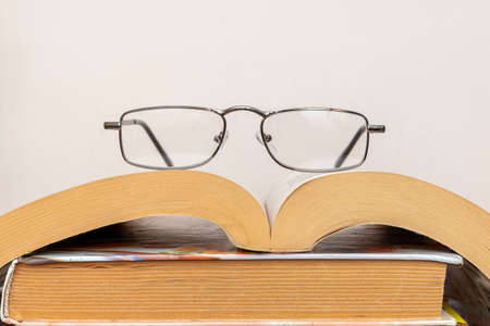 Reading glasses on a stack of books close upの写真素材