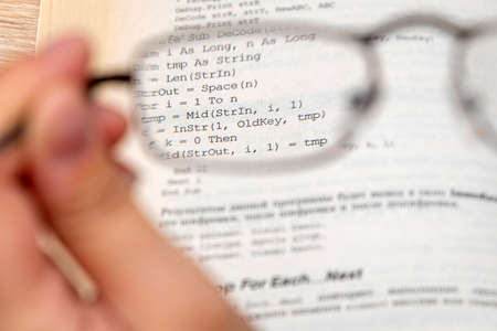 View through glasses in hand on a text in the bookの写真素材