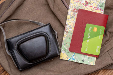 Tourist map, photo camera, credit card, passport in the pocket of the travel backpack