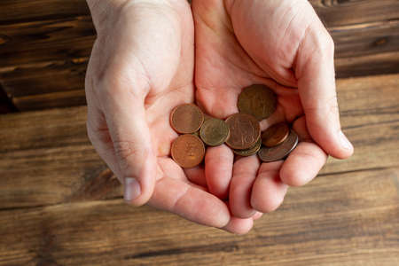 Two hands holding coins in the palms.
