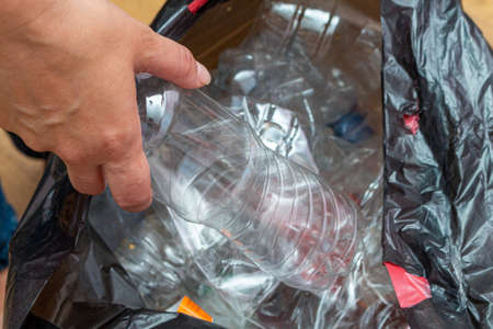 Black packet with lot of used plastic bottles for recycling in handsの写真素材