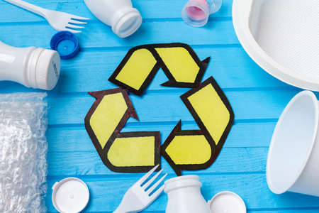 white plastic waste with recycling on blue background. Eco concept with copy space