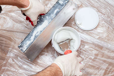 mixing, stirring gypsum putty with a spatula close-up