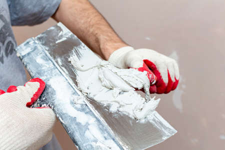 mixing, stirring gypsum putty with a spatula close-upの写真素材