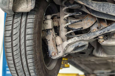car suspension repair on a lift jack in auto service close-upの写真素材