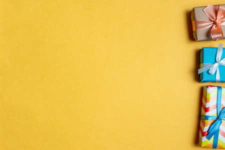Colorful gift boxes on a yellow background close up. The concept of preparing for the holidays New...