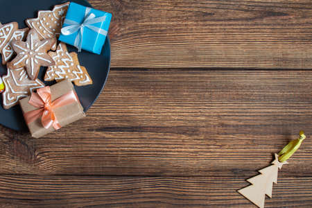 Colorful gift boxes cookies dark black dish on a wooden dark background. The concept of preparing for the holidays New Year and Christmas.の写真素材