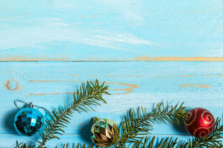 Colorful fir, spruce brunches, toy on a blue wooden background close up. The concept of preparing...