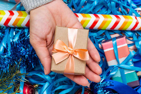 hands in a knitted sweater holding gift present box. Christmas holidays preparation concept.